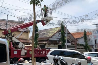 DIPERBAIKI: Dinas PKPL Kudus telah memperbaiki lampu hias yang membentang di Kawasan City Walk Jalan Sunan Kudus kemarin. Sebelumnya lampu itu rusak karena diterpa angin dan hujan lebat Minggu (26/9). (DONNY SETYAWAN/RADAR KUDUS)