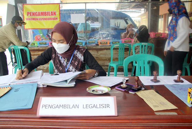 MENINGKAT PESAT: Petugas Dindukcapil Rembang saat memproses legalisir kependudukan yang salah satunya dipergunakan untuk syarat pengisian perangkat desa, kemarin. (WISNU AJI/RADAR KUDUS)
