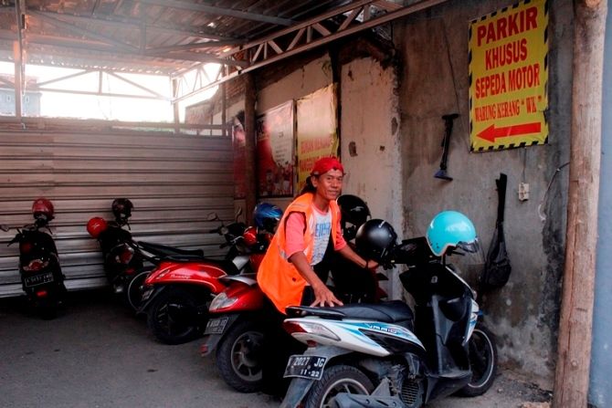 KANG PARKIR: Untuk memenuhi kebutuhan hidup, Surayanto menjual barang dan menjadi tukang parkir selama pandemi. (ANDRE FAIDHIL FALAH/RADAR KUDUS)