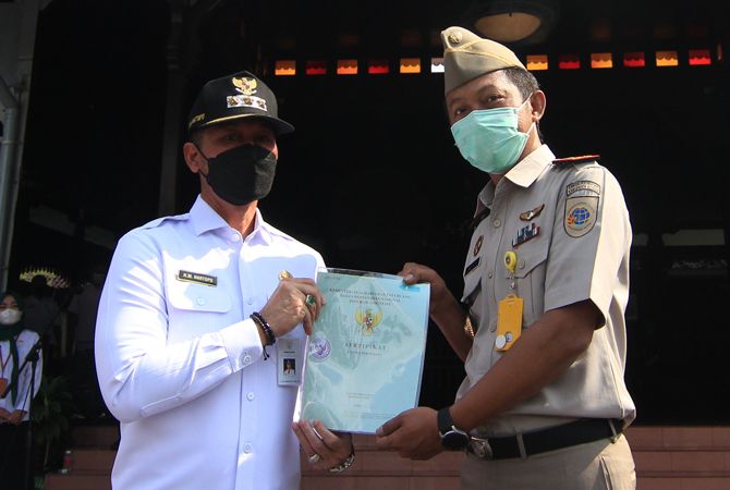 HAPUS MAFIA TANAH: Bupati Kudus Hartopo menerima sertifikat tanah secara simbolis dalam rangka ulang tahun UUPA di Pendopo kabupaten Kudus kemarin. (DONNY SETYAWAN/RADAR KUDUS)