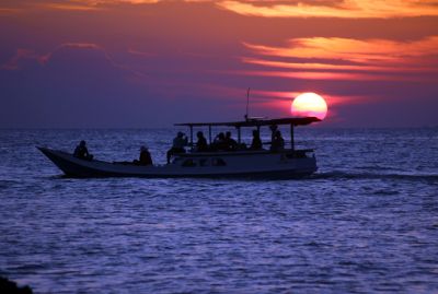 MENAWAN: Wisatawan menikmati panorama matahari terbenam di Pantai Ujung Gelam baru-baru ini. (MOH. NUR SYAHRI MUHARROM/RADAR KUDUS)