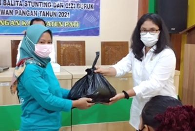 SOSIAL: Kabid Ketersediaan dan Kerawanan Pangan Dinas Ketapang Kabupaten Pati Alfianingsih Firmanwigati memberikan bantuan ke warga miskin yang memiliki balita stunting di Tompe Gunung, Sukolilo kemarin. (DISKETAPANG FOR RADAR KUDUS)