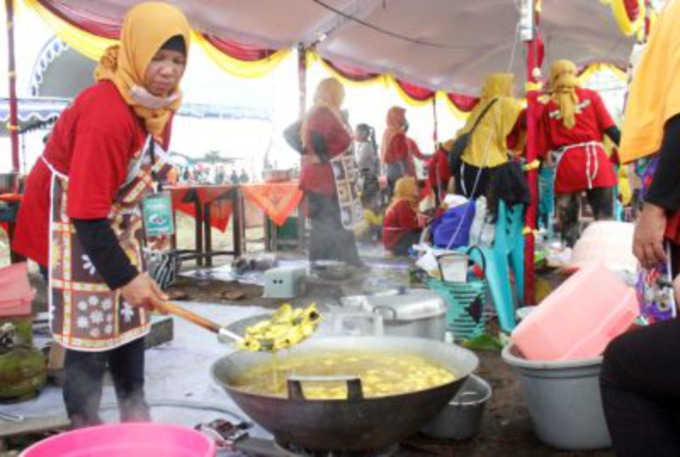 FESTIVAL: Ibu-ibu gotong-royong memasak bandeng mrico di Pantai Dasun kemarin. (VACHRI RINALDY LUTFIPAMBUDI/RADAR KUDUS)