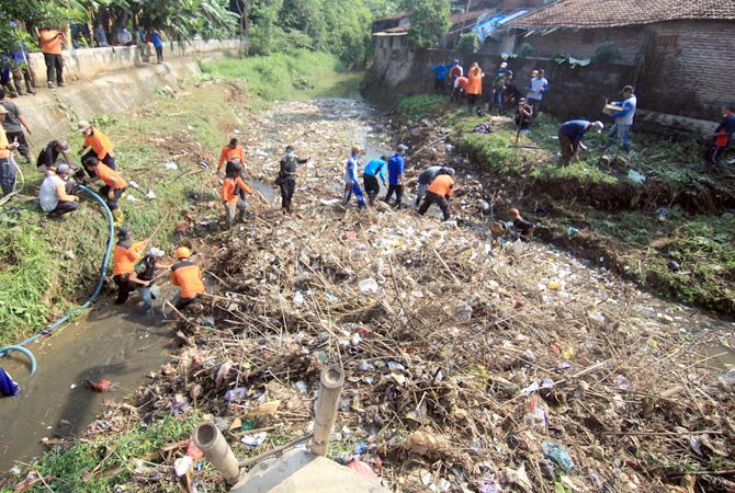 ANTISIPASI BANJIR: Aparat gabungan membersihkan sampah dan batang bambu yang menumpuk di bawah jembatan Jalan Raya Kudus-Pati tepatnya Desa Ngembalrejo, Bae, Kudus. (DONNY SETYAWAN/RADAR KUDUS)