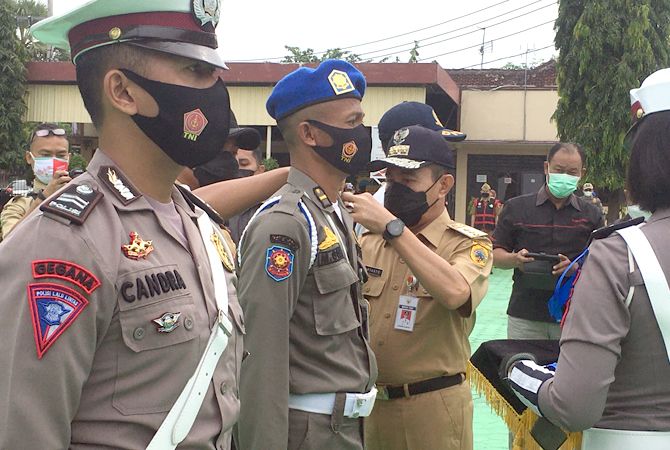DICANTUMKAN: Bupati Pati Haryanto memasang pin sebagai tanda mulainya petugas melaksanakan operasi zebra candi 2021 di Mapolres Pati kemarin (15/11). (ANDRE FAIDHIL FALAH/RADAR KUDUS)