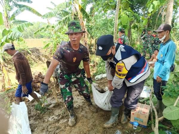 KOMPAK : Personel Koramil 04/Kayen bersama masyarakat dan Polsek Kayen membangun Kembali tanggul yang jebol kemarin. (KODIM 0718/PATI FOR RADAR KUDUS)