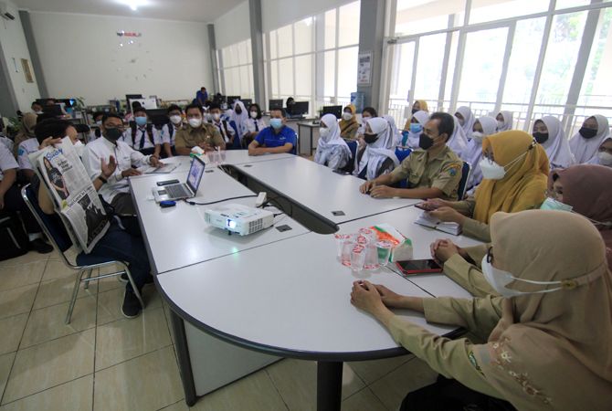 BELAJAR MENULIS: Puluhan pelajar dari SMP 5 Kudus melakukan kunjungan redaksi untuk belajar membuat Koran Jawa Pos Radar Kudus ditemui Redpel M Ulin Nuha dan GM Radar Kudus online Kholid Hazmi kemarin. (DONNY SETYAWAN/RADAR KUDUS)