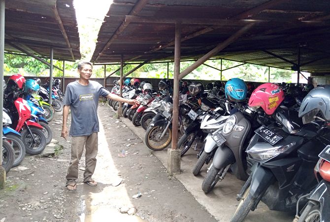 MENGECEK: Penjaga parkir Suwandi menunjukan titik lokasi terjadinya pencurian kemarin. (EKO SANTOSO/RADAR KUDUS)