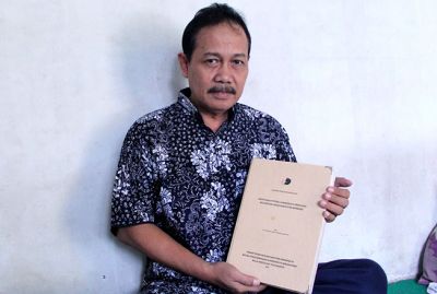 BUKU LANGKA: Ernantoro menunjukkan buku laporan penelitian Lasem yang dia terlibat dalam penyusunannya. (SAIFUL ANWAR/RADAR KUDUS)