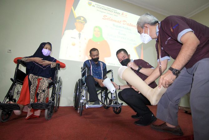 TAMBAH PELAYANAN:: Bupati Kudus Hartopo dan Direktur RSUD Loekmonohadi Aziz Achyar memberi bantuan kaki palsu kepada dua pasien memperingati HKN ke-57 di aula rumah sakit itu kemarin. (DONNY SETYAWAN/RADAR KUDUS)
