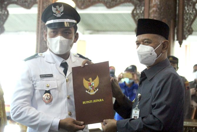 SAH : Bupati Jepara Dian Kristiandi (kanan) menyerahkan berkas pelantikan kepala desa PAW kepada Masheru Hepnanto (kiri) sebagai Kades PAW Desa Kaliaman, Kembang, kemarin. (MOH. NUR SYAHRI MUHARROM/RADAR KUDUS)