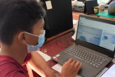 ADA ATURAN BARU: Warga melihat pengumuman PPDB di web resmi sekolah wilayah Grobogan kemarin. (SAIFUL ANWAR/RADAR KUDUS)