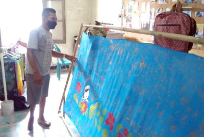 BANTU PEREKONOMIAN DIFABEL: Suratno memperlihatkan salah satu hasil batik ciprat karyanya di tempat produksi baru-baru ini. (ANDRE FAIDHIL FALAH/RADAR KUDUS)