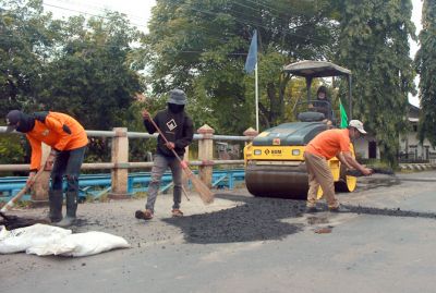 DIMULAI: Petugas klinik jalan memperbaiki kerusakan darurat menjelang Lebaran lalu. Pekan ini pengerjaan perbaikan dan peningkatan jalan bisa dimulai. (MOH. NUR SYAHRI MUHARROM/RADAR KUDUS)