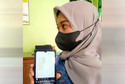 TUNJUKKAN BUKTI: Salah satu korban tunjukkan bukti arisan online di balai desa Doplang, Kecamatan Jati kemarin. (SUBEKAN/RADAR KUDUS)