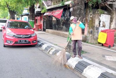 BERSIH-BERSIH: Salah satu tenaga kontrak kebersihan Dinas Perumahan Kawasan Permukiman dan Lingkungan Hidup (PKPLH) Kudus menyapu, kemarin. (EKO SANTOSO/RADAR KUDUS)