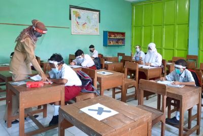 SIAP BELAJAR: Guru mengajar siswanya di dalam kelas dan penerapan prokes ketat saat simulasi PTM. (INDAH SUSANTI/RADAR KUDUS)