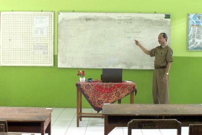 TAK JELAS: Seorang guru di SMPN 3 Jepara mengajar secara daring di kelas belum lama ini. Di Jepara PTM-nya menunggu intruksi Bupati Jepara. (MOH. NUR SYAHRI MUHARROM/RADAR KUDUS)