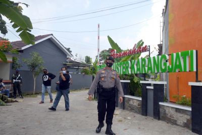 HARI KEDUA: Anggota polisi berjaga di pintu masuk Perumahan Grand Cluster Karangjati. Semua rumah KPR di perumahan tersebut disita Bareskrim Polri. (SUBEKAN/RADAR KUDUS)