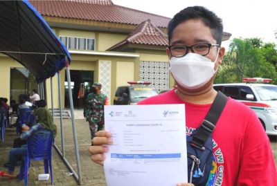 BUKTI: Salah satu warga menunjukkan kartu vaksinasi Covid-19. (SUBEKAN/RADAR KUDUS)