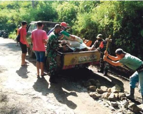 Sejumlah masyarakat tengah melakukan perbaikan jalan secara swadaya di Jalan Kalibawang-Sapuran. (Sigit Rahmanto/Jawa Pos Radar Semarang)