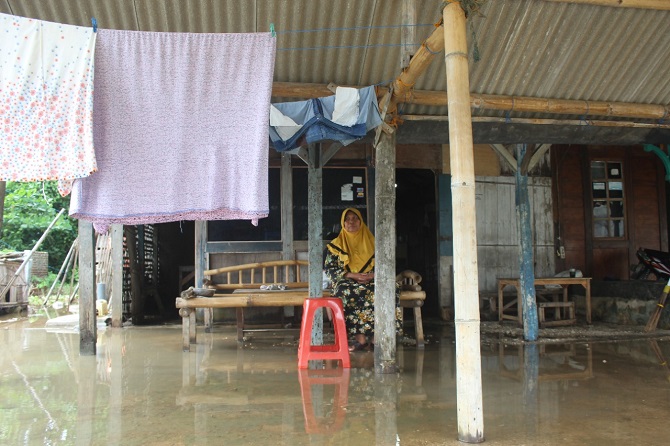 PASRAH: Salah satu warga Praweyan, Bandengan Jepara, di tengah genangan air di rumahnya, Sabtu (4/12). (Nibros Hassani/Radar Kudus)