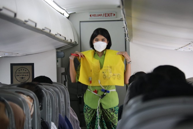 PERLU DIPERHATIKAN: Pramugari di pesawat ATR maskapai Citilink dari Bandara Halim Perdanakusuma tujuan Bandara Ngloram, Blora, memeragakan pemakaian pelampung saat kondisi darurat. (SUBEKAN/RADAR KUDUS)