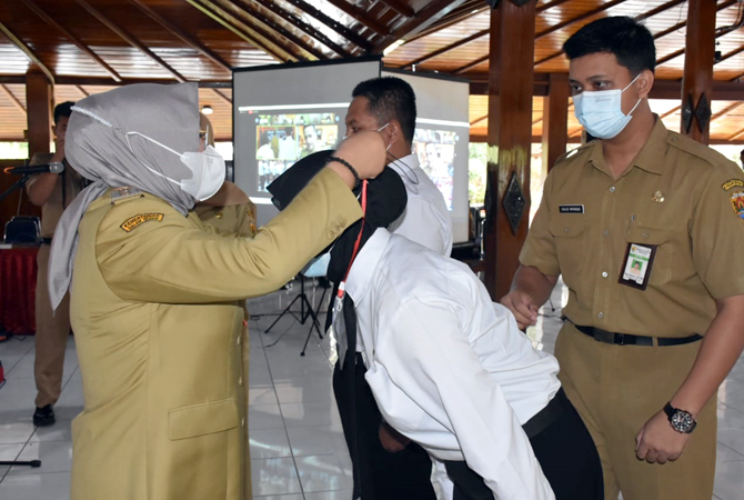 BERI SELAMAT: Bupati Grobogan Sri Sumarni mengalungkan tanda pengenal dan piagam penghargaan kepada CPNS yang lolos pelatihan dasar di pendapa kabupaten kemarin. (SIROJUL MUNIR/RADAR KUDUS)