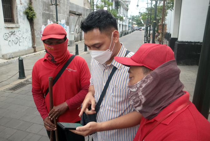 EDUKASI: Petugas BPJamsostek Cabang Kudus saat memberikan edukasi tentang pentingnya perlindungan kerja kepada para asongan dan pekerja lain di kawasan Kota Lama Semarang. Melalui beragam inovasi, BPJamsostek terus melayani semua elemen masyarakat dengan
