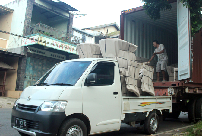 BERANGKAT: Pekerja memindahkan mebel-mebel dari pick-up ke dalam truk kontainer untuk diekspor ke luar negeri. (MOH. NUR SYAHTRI MUHARROM/RADAR KUDUS)