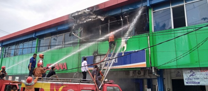 BERJIBAKU: Petugas damkar memanjat tangga untuk memadamkan api di kantor BRI Pasar Kliwon.