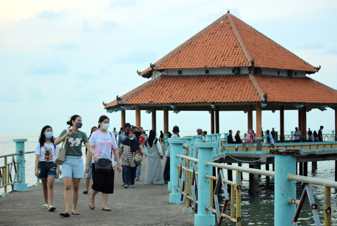 RAMAI: Pengunjung menikmati suasana laut di atas jembatan kawasan Pantai Kartini Jepara kemarin. (MOH. NUR SYAHRI MUHARROM/RADAR KUDUS)