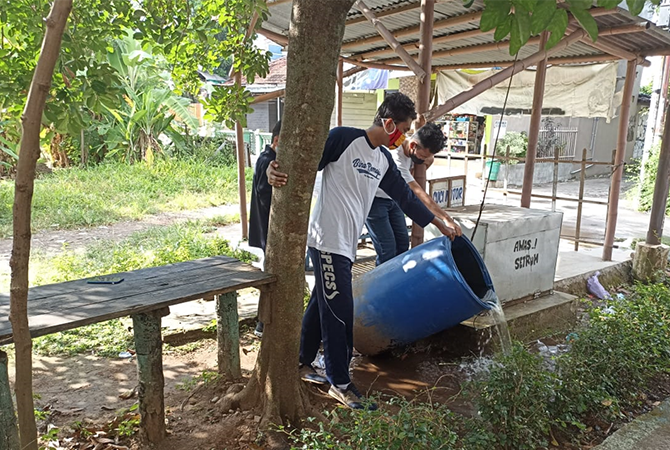 BUANG GENANGAN: Petugas Puskesmas Ngembal Kulon bersih-bersih genangan air untuk membasmi sarang nyamuk. (INDAH SUSANTI/RADAR KUDUS)