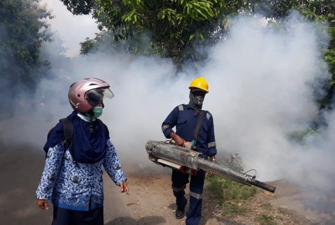 EFEKTIF PSN: Petugas Dinas Kesehatan Kabupaten Blora fogging sekitar rumah warga belum lama ini. (SUBEKAN/RADAR KUDUS)
