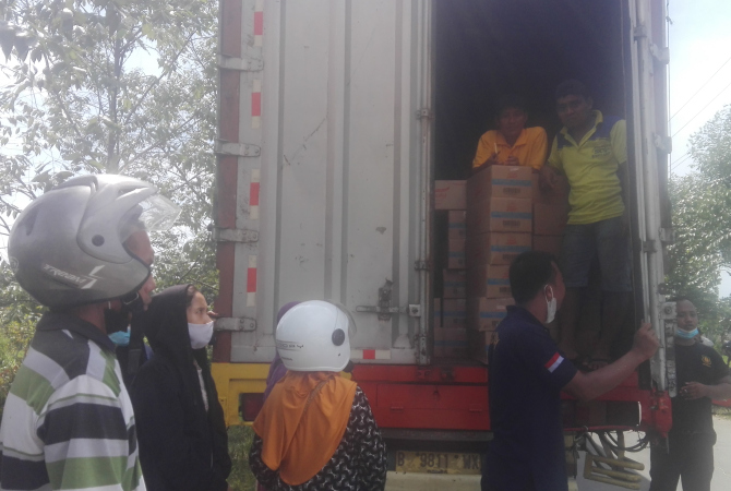 DICEGAT DI JALAN: Sejumlah warga berebut minyak goreng dari distributor di depan Pasar Baru Kudus pada Sabtu (19/2) . (ARIKA KHOIRIYA/RADAR KUDUS)