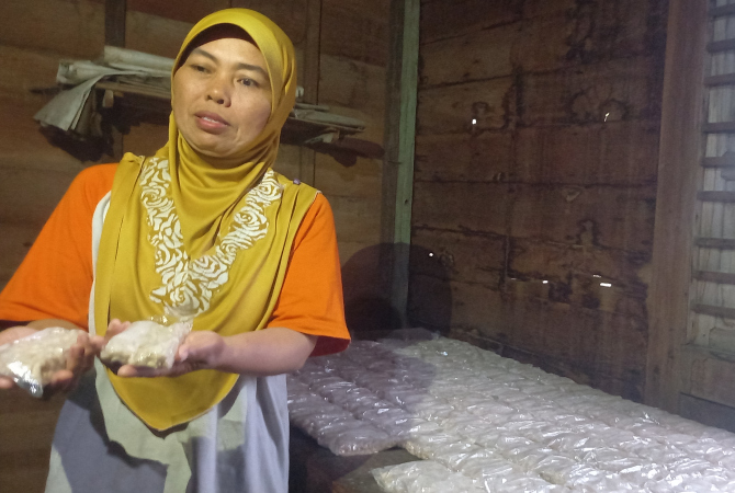 SETENGAH MATANG: Kartini, salah satu pembuat tempe di Blora menunjukkan hasil produksinya. (VACHRI RINALDY L/RADAR KUDUS)