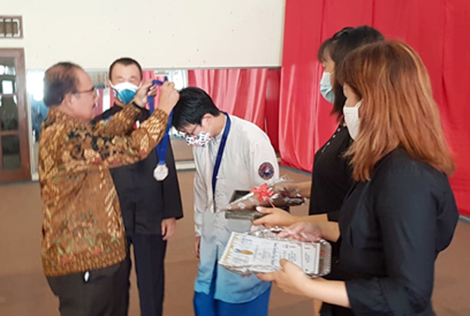 PENYERAHAN MEDALI: Ketua pengganti antar waktu Kormi Kudus Trisno Suwandi menyerahkan medali Kejurda pada atlet Aliansi Kungfu Tradisional Indonesia (AKTI). (KORMI FOR RADAR KUDUS)