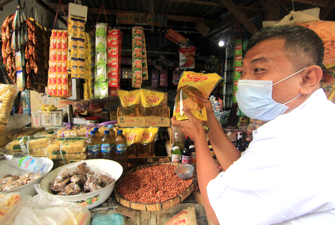 AWASI PENJUALAN MINYAK GORENG: Kabid Fasilitasi Perdagangan, Promosi, dan Perlindungan Konsumen PerImam Prayitno menyidak pedagang minyak goreng di Pasar Bareng Jekulo. (DONNY SETYAWAN/RADAR KUDUS)