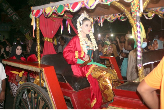IKONIK: Choiru Nisa Wulandari, warga Desa Kriyan, Kalinyamatan, Jepara, menjadi Ratu Kalinyamatan duduk di dokar sambil diiringi danyang dalam Festival Baratan kemarin malam. (NIBROS HASSANI/RADAR KUDUS)