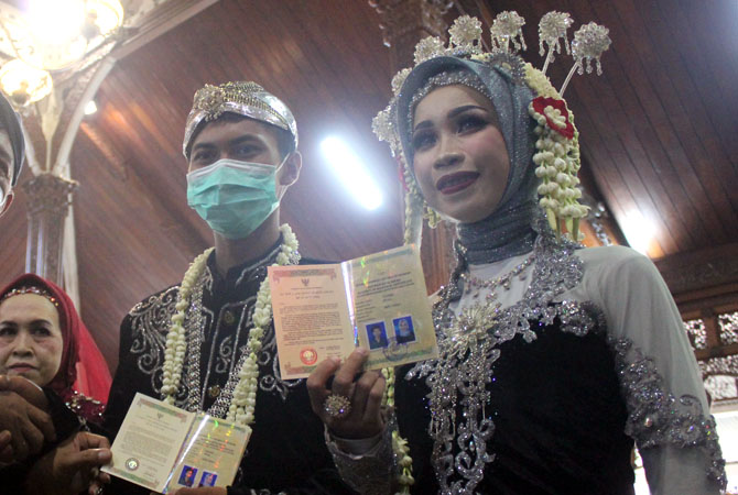 LEGA: Pasangan pengantin paling muda Habib Rizki dan Dela menunjukkan surat nikah di Pendapa Kabupaten Jepara kemarin. (NIBROS HASSANI/RADAR KUDUS)