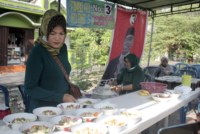 PERTARUNGAN: Pedagang sedang menyiapkan makanan gratis yang disiapkan oleh salah satu cakades di Desa Kaliputu, Kudus, kemarin. (GALIH ERLAMBANG W/Radar Kudus)