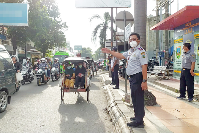 MACET: Kepala Dinas Perhubungan Catur Sulistiyanto mengurai kemacetan di jalan Kawasan Wisata Taman Menara Kudus kemarin. (DISHUB KUDUS FOR RADAR KUDUS)