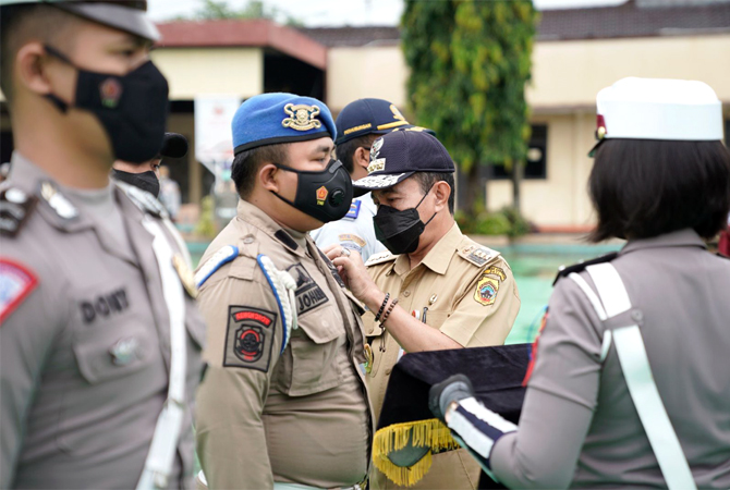 DIMULAI: Bupati Pati Haryanto memasangkan pin sebagai tanda dimulainya operasi candi 2022 di halaman mapolres setempat pada Selasa (1/3). (HUMAS POLRES FOR RADAR KUDUS)