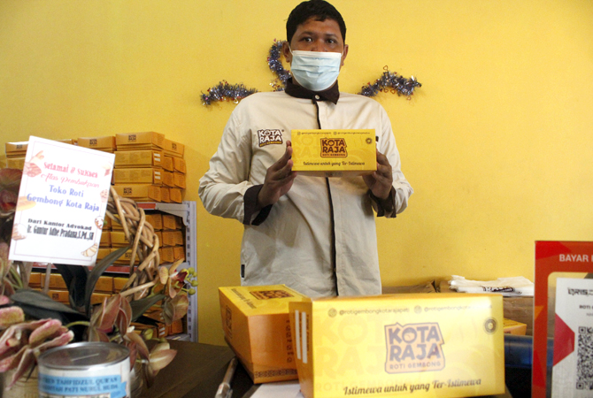 MENGGIURKAN: Pemilik Roti Gembong Kota Raja menunjukkan produknya di toko yang beralamat di Jalan Dr. Susanto nomor 57 Kelurahan Pati Lor belum lama ini. (ANDRE FAIDHIL FALAH/RADAR KUDUS)