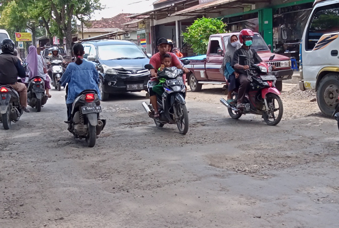 HATI-HATI: Beberapa kendaraan menurunkan laju kendaraan saat melintasi jalan rusak di Kunduran beberapa waktu lalu. (AHMAD ZA’IIMUL CHANIEF/RADAR KUDUS)