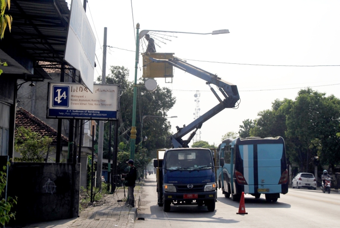 PERBAIKI: Petugas dari Dinas Perhubungan Kabupaten Rembang melakukan perbaikan LPJU di jalan nasional beberapa waktu lalu. (WISNU AJI/RADAR KUDUS)