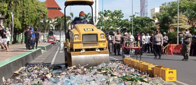 HASIL RAZIA: Kendaraan berat memusnahkan ribuan botol miras hasil operasi Ketupat Candi di Kudus. (EKO SANTOSO/RADAR KUDUS)