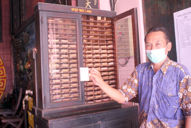 BANYAK YANG COCOK: Suwoto, pengurus Kelenteng Hian Thian Siang Tee, Welahan, Jepara, menunjukkan resep lama yang masih digunakan sebagai rujukan pengobatan hingga kini. (NIBROS HASSANI/JAWA POS RADAR KUDUS)