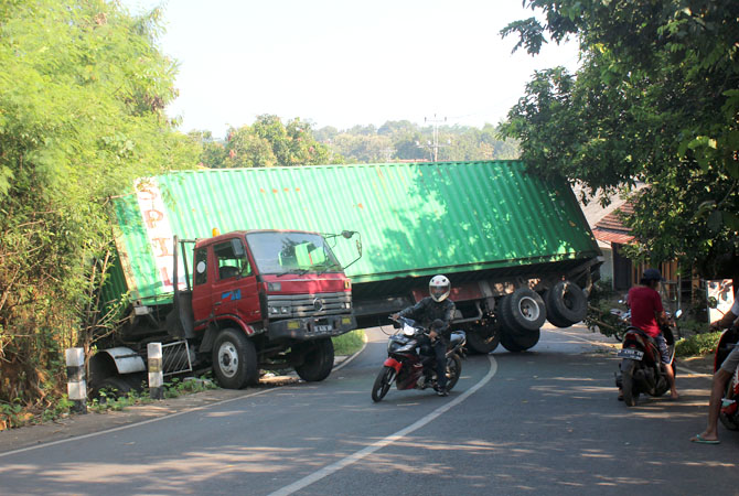 TUTUP JALAN: Seorang pengendara sepeda motor berbalik arah saat melewati jalan Mantingan karena tertutup truk kontainer kemarin. (NIBROS HASSANI/RADAR KUDUS)