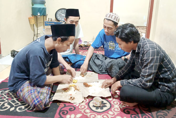 SEBUNGKUS BERSAMA:Wartawan Radar Kudus Eko Santoso sahur bersama santri. (DOK.RADAR KUDUS)